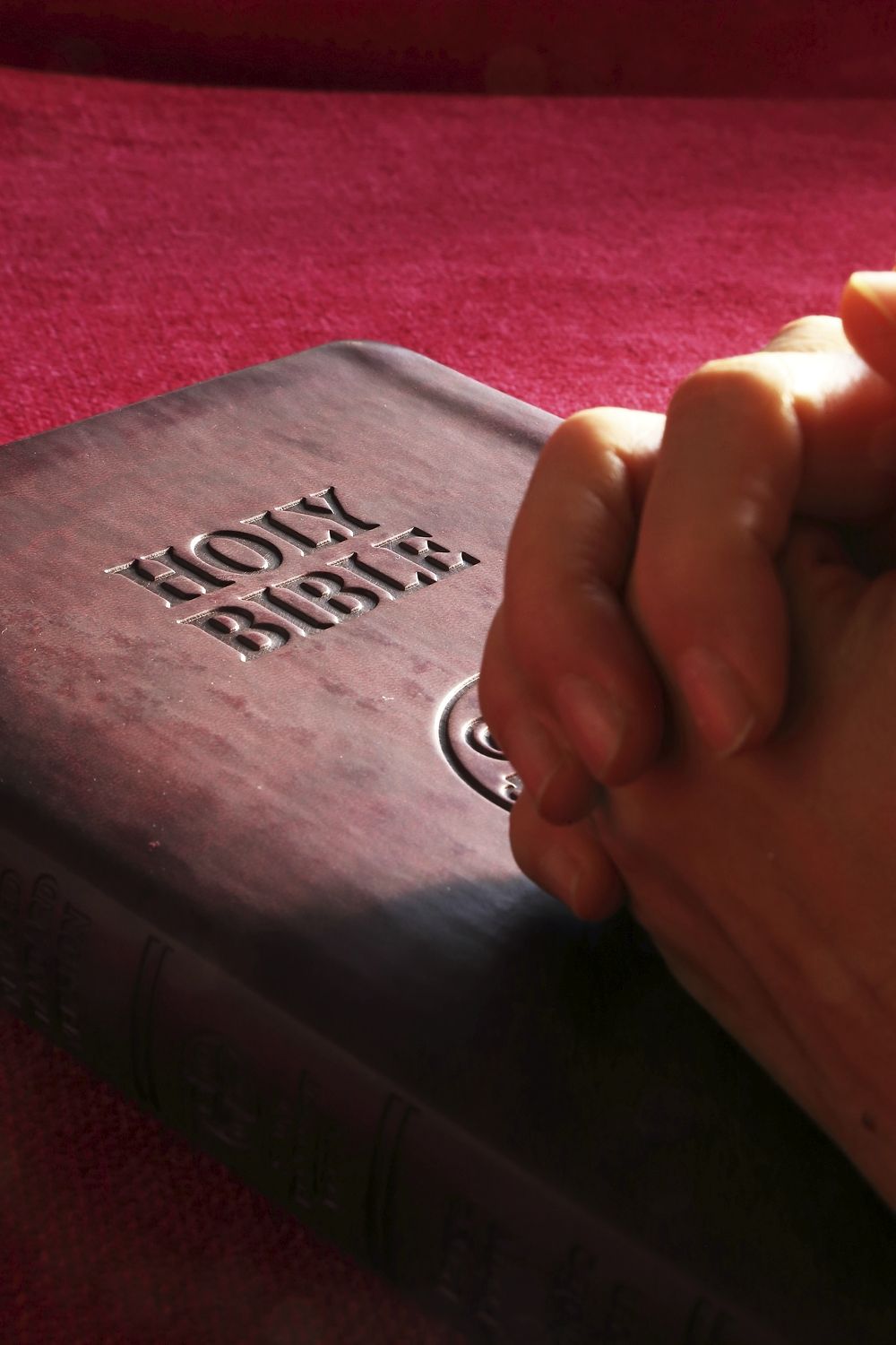 Free hands praying on bible